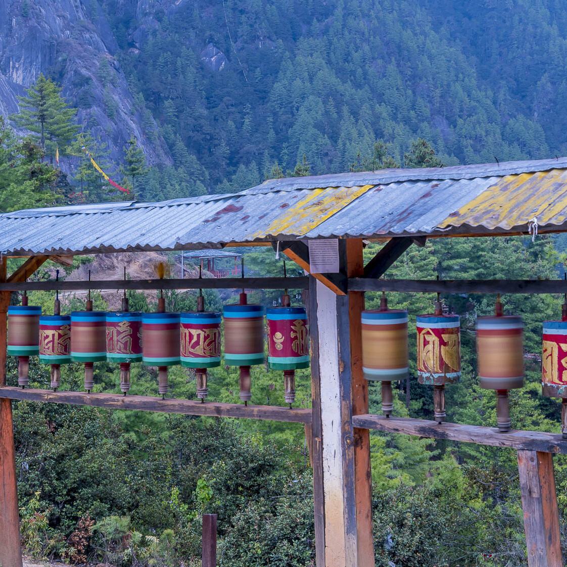 Prayer spinners in action in front of a Bhutanese mountain