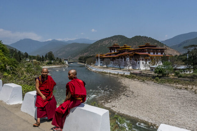 Two Bhutanese monks in front of a temple