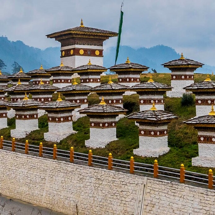 Scenic road leading to a large Bhutanese temple